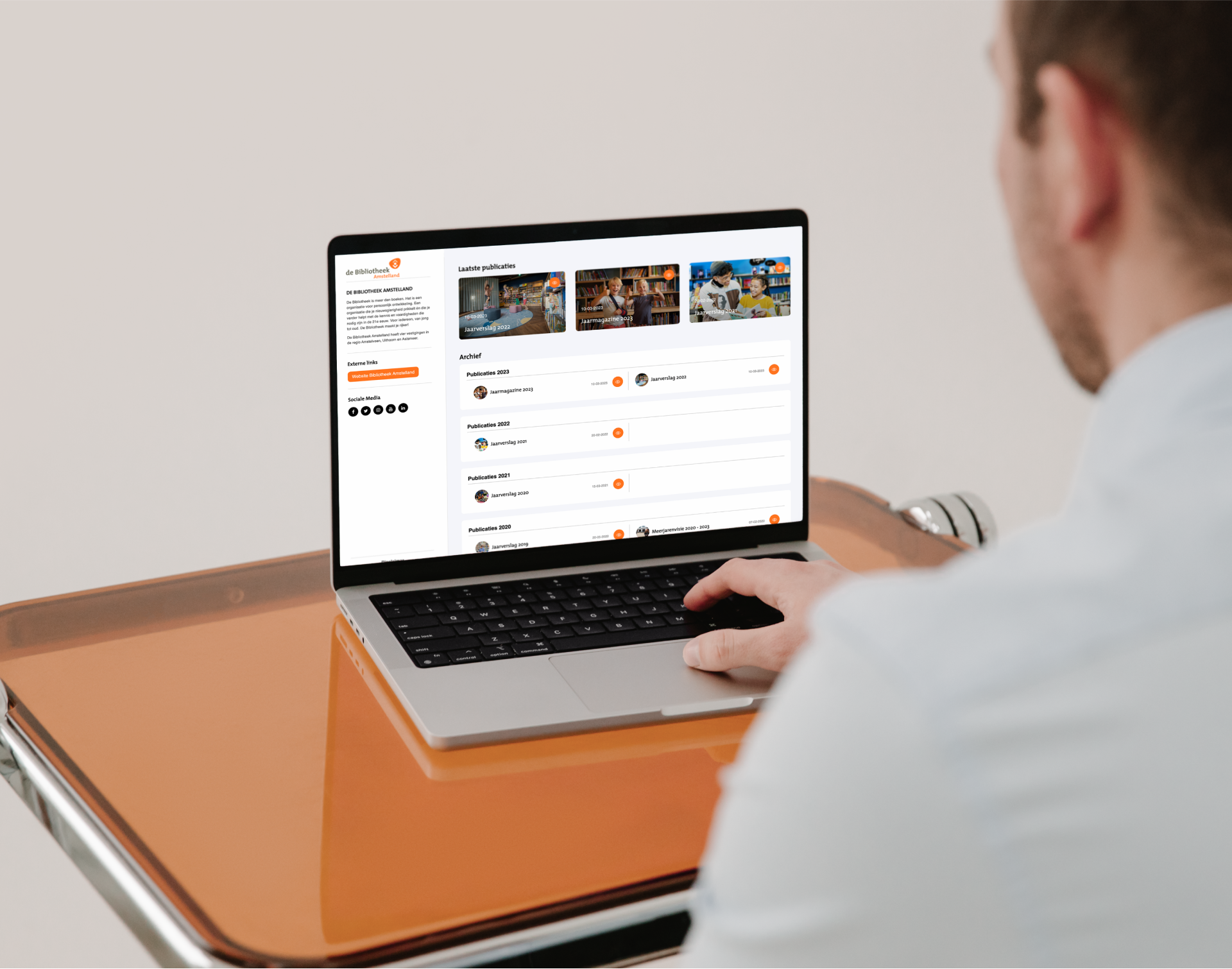 daily creative agency - bibliotheek - amstelland - website - jaarrapport - digital magazine - development - website - mockup - man behind macbook on retron table2